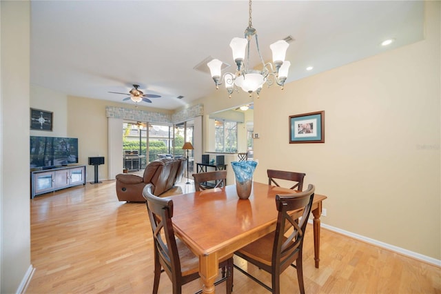 4532 Shark Dr, Bradenton, FL 34208 - dining area with light wood-type flooring, baseboards, and ceiling fan with notable chandelier