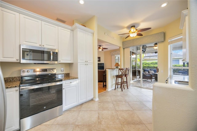 4532 Shark Dr, Bradenton, FL 34208 - kitchen with visible vents, a ceiling fan, white cabinetry, and stainless steel appliances