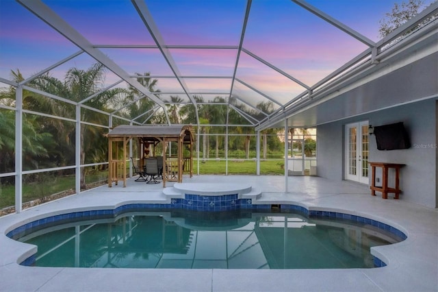 view of swimming pool with a lanai, french doors, and a patio