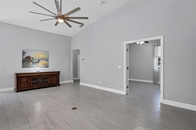 unfurnished living room with ceiling fan, light hardwood / wood-style floors, and high vaulted ceiling