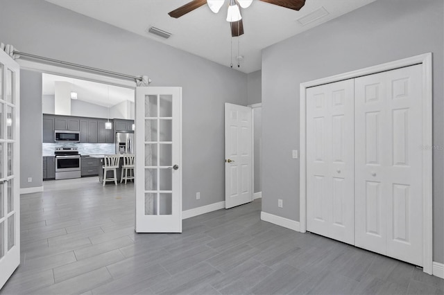 bedroom with french doors, vaulted ceiling, ceiling fan, light hardwood / wood-style floors, and a closet