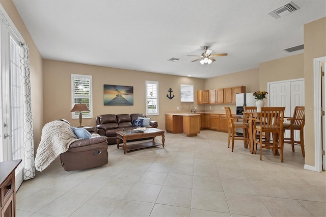 tiled living room featuring ceiling fan and sink