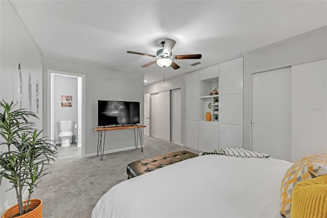 carpeted bedroom with ceiling fan and ensuite bath