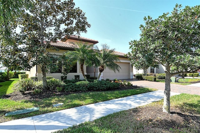 view of front of home with a garage, stucco siding, decorative driveway, and a tiled roof