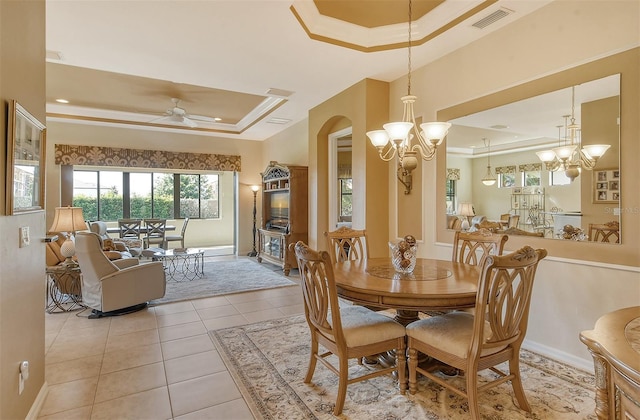 dining area featuring a raised ceiling, visible vents, ornamental molding, light tile patterned flooring, and baseboards