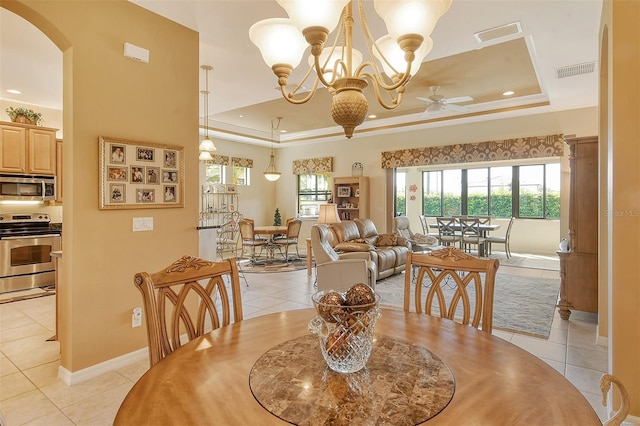 dining space with light tile patterned floors, a raised ceiling, and visible vents