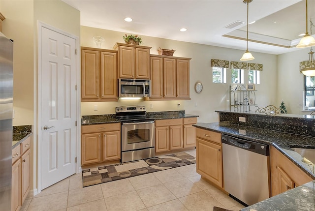 kitchen with stainless steel appliances, dark stone countertops, visible vents, and pendant lighting