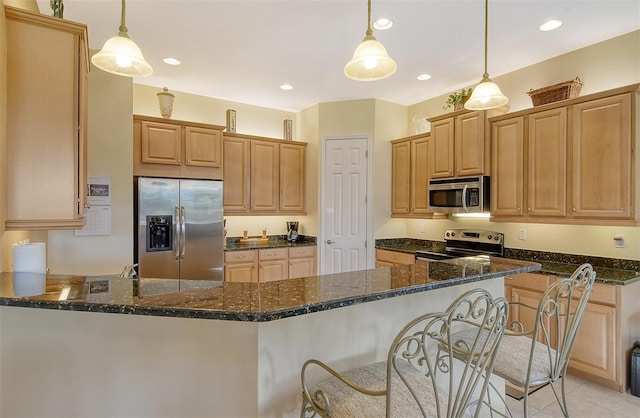 kitchen featuring dark stone counters, appliances with stainless steel finishes, a peninsula, hanging light fixtures, and recessed lighting