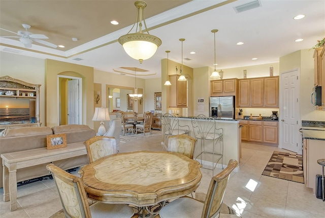 dining space with ceiling fan with notable chandelier and light tile patterned floors