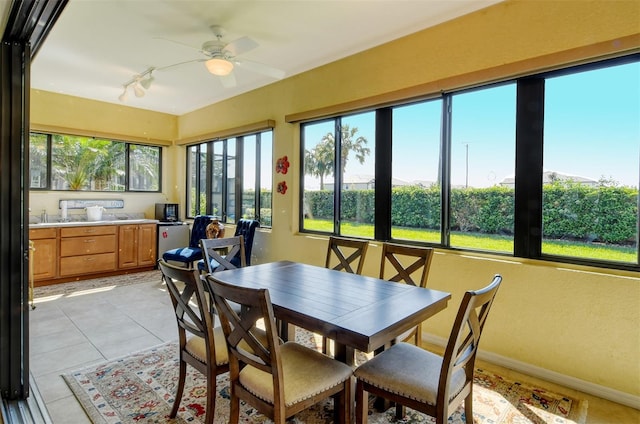 sunroom / solarium featuring ceiling fan and track lighting