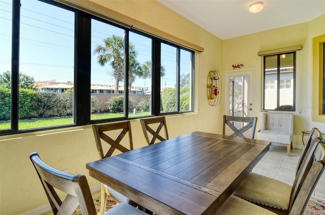 dining area with light tile patterned flooring and baseboards