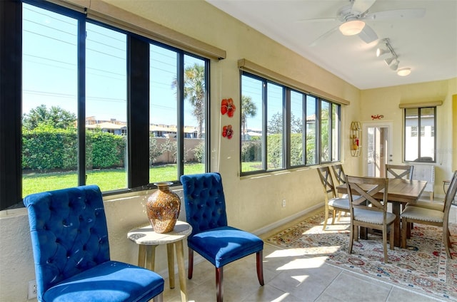 sunroom / solarium featuring ceiling fan and track lighting