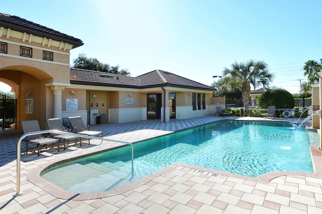 community pool featuring a patio area and fence