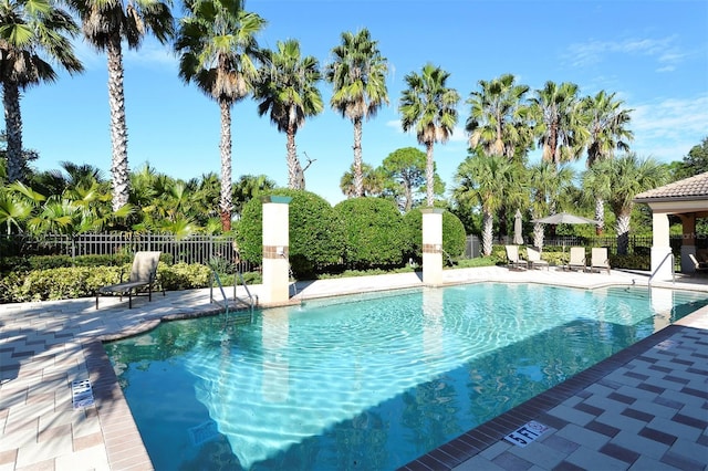 community pool with fence and a patio