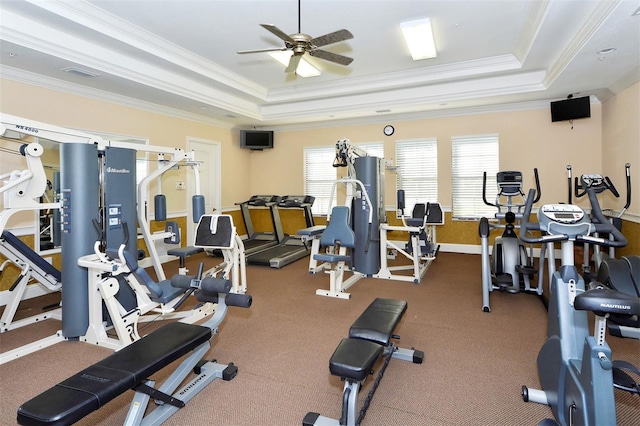 exercise room featuring ornamental molding, a tray ceiling, and ceiling fan