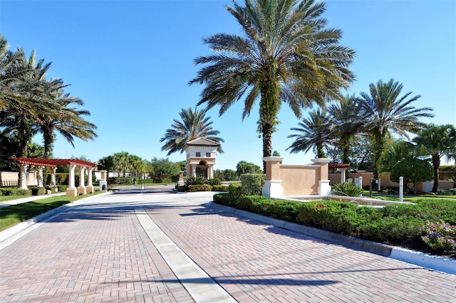 view of road with curbs, a gated entry, and sidewalks