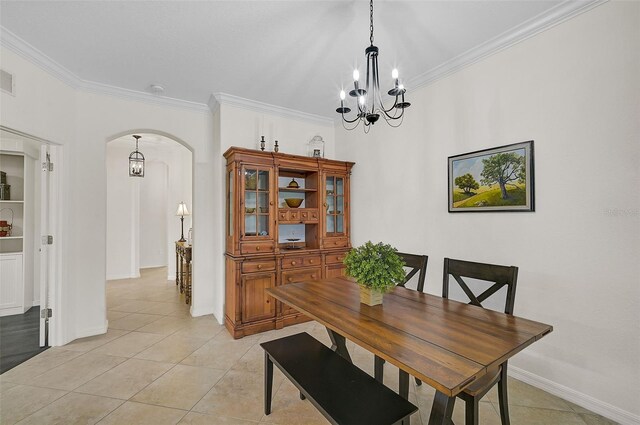 dining area featuring ornamental molding, light tile patterned floors, and an inviting chandelier