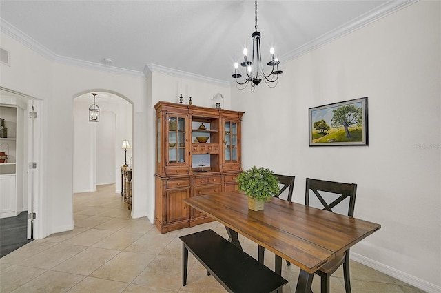 dining room featuring crown molding, a notable chandelier, light tile patterned floors, and arched walkways