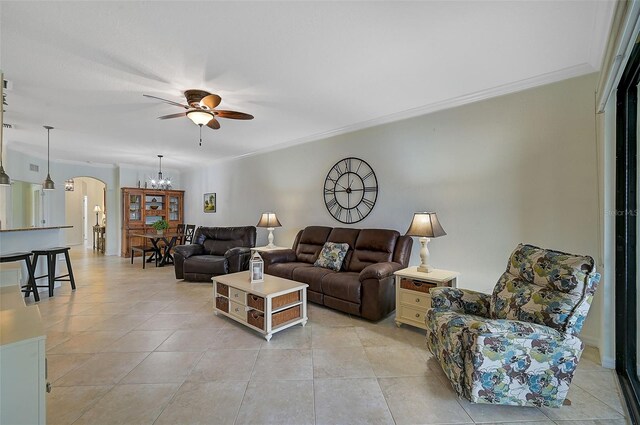 living room featuring ceiling fan with notable chandelier, light tile patterned flooring, and ornamental molding