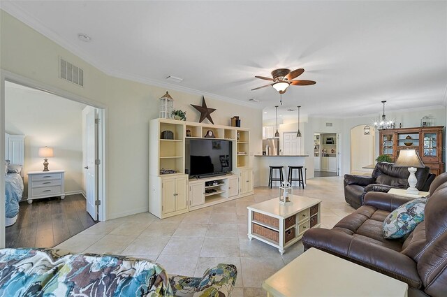 living room featuring light hardwood / wood-style flooring, ceiling fan with notable chandelier, and ornamental molding