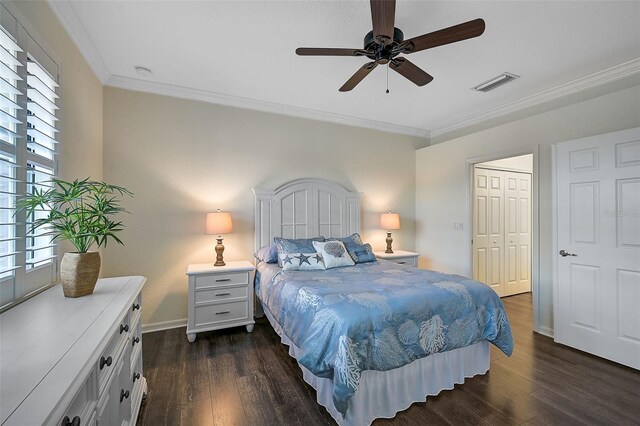 bedroom featuring crown molding, ceiling fan, a closet, and dark wood-type flooring