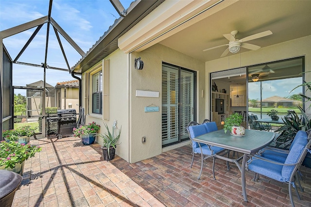 view of patio / terrace featuring ceiling fan, grilling area, and glass enclosure