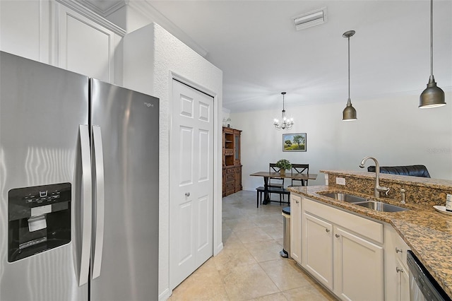 kitchen with sink, stainless steel appliances, hanging light fixtures, and dark stone counters