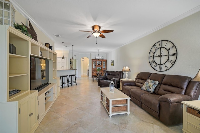 tiled living room featuring ceiling fan with notable chandelier and ornamental molding