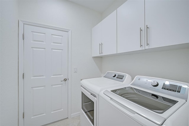 clothes washing area with cabinets and independent washer and dryer