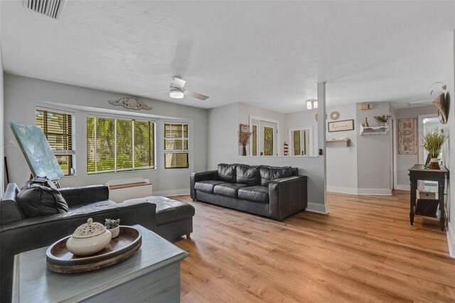 living room with ceiling fan and light hardwood / wood-style flooring