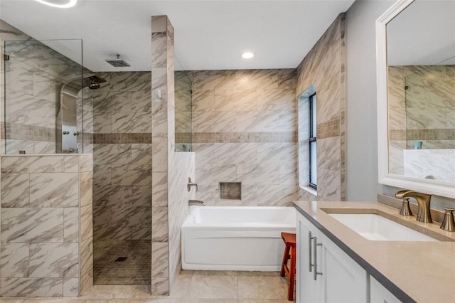 bathroom with vanity and shower with separate bathtub