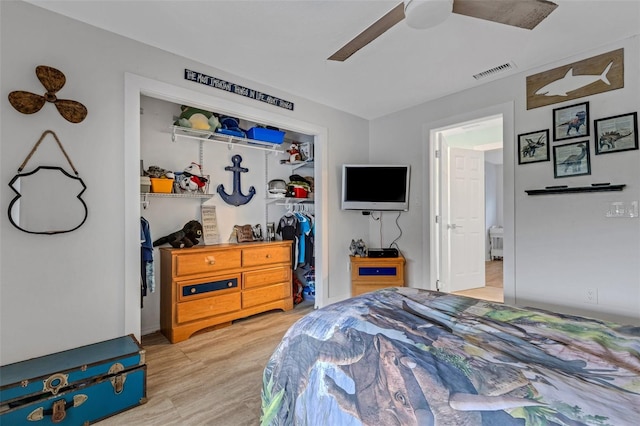 bedroom featuring light hardwood / wood-style flooring, ceiling fan, and a closet