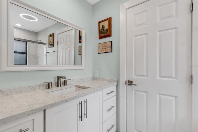 bathroom with vanity and a shower with shower door