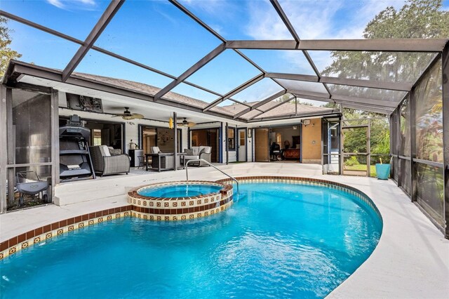 view of swimming pool featuring ceiling fan, a patio, glass enclosure, and an in ground hot tub