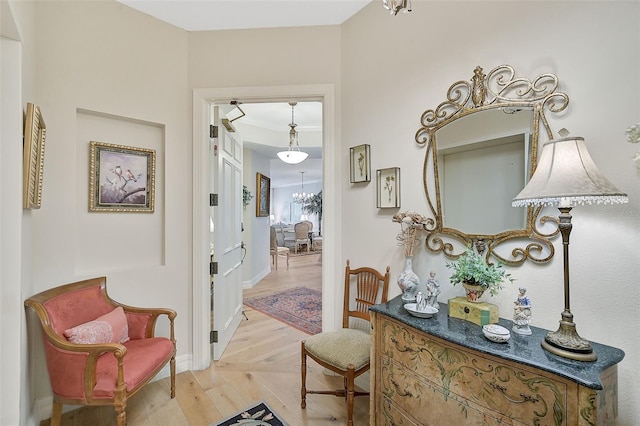 hall featuring a notable chandelier and light hardwood / wood-style floors