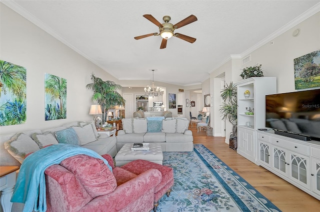 living room featuring ceiling fan with notable chandelier, light hardwood / wood-style flooring, and ornamental molding