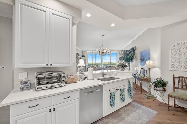 kitchen featuring pendant lighting, a chandelier, light hardwood / wood-style floors, tasteful backsplash, and stainless steel dishwasher