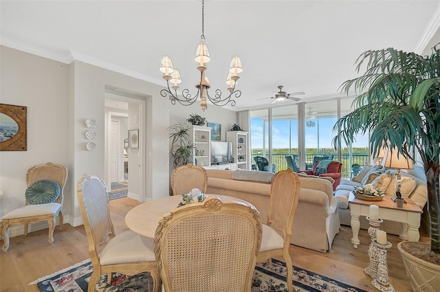 dining space featuring ornamental molding, light hardwood / wood-style floors, ceiling fan with notable chandelier, and expansive windows