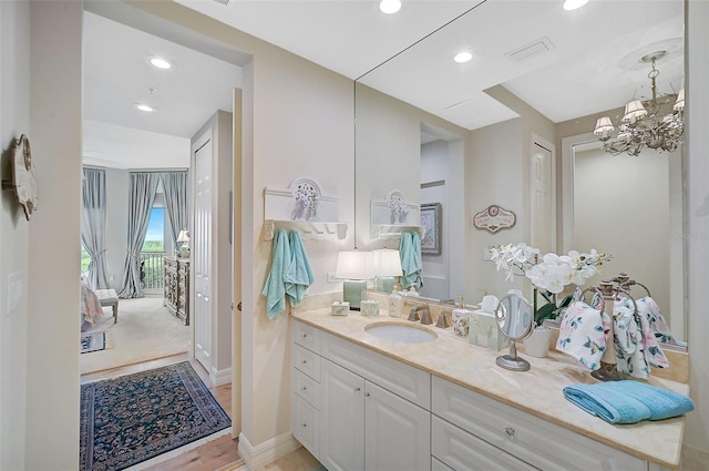 bathroom featuring a notable chandelier, vanity, and hardwood / wood-style flooring