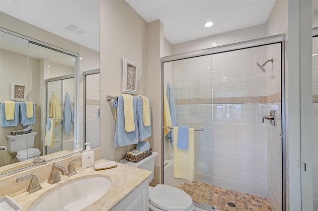 bathroom featuring vanity, toilet, and an enclosed shower