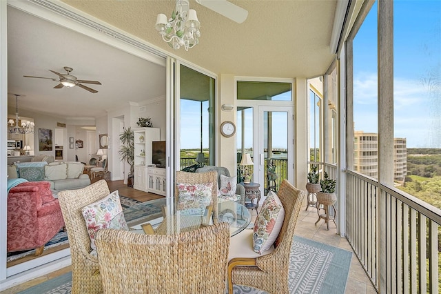 sunroom with ceiling fan with notable chandelier