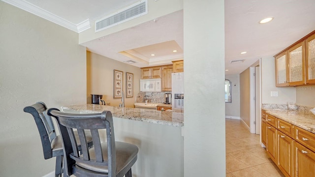 kitchen with ornamental molding, visible vents, fridge with ice dispenser, and white microwave