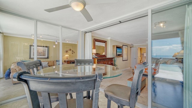 dining space with baseboards, a ceiling fan, and crown molding