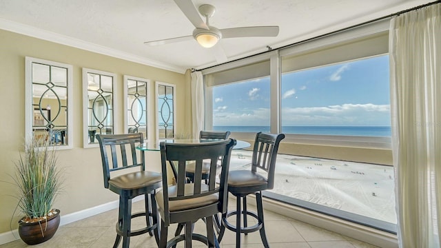 sunroom / solarium with a ceiling fan and a water view