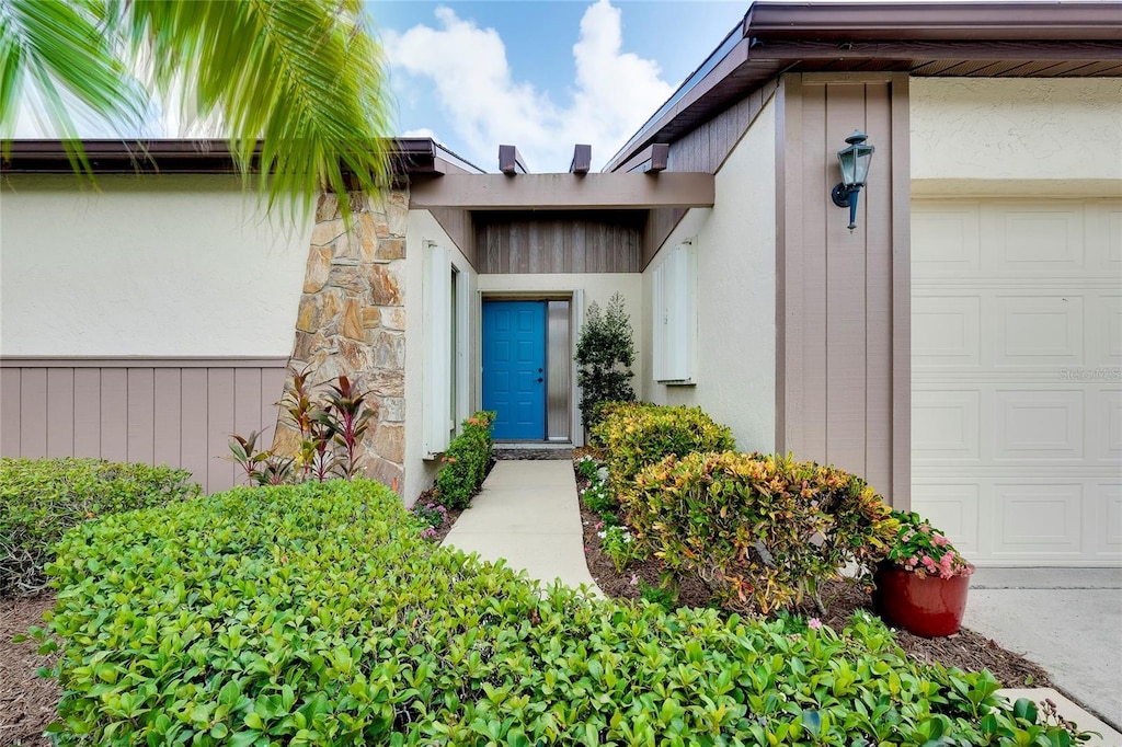 doorway to property with stucco siding and a garage