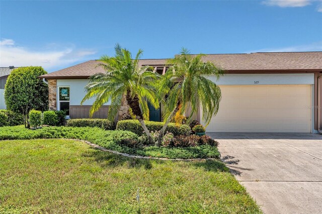 single story home with a garage and a front lawn