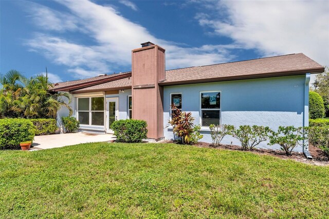 rear view of property featuring a lawn