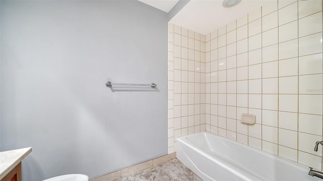 full bathroom featuring tile patterned flooring, tiled shower / bath combo, vanity, and toilet