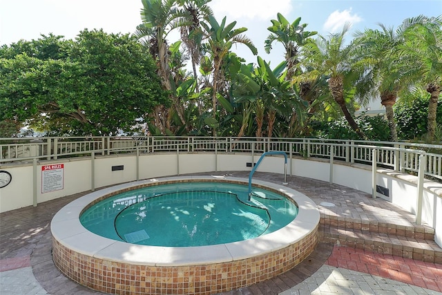 view of swimming pool featuring a hot tub