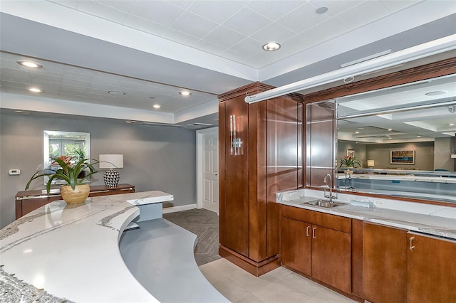 bathroom featuring vanity, a tray ceiling, a shower with shower door, and tile patterned flooring